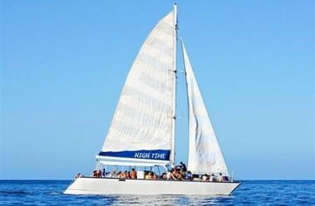 Sailing Yacht High Time On Calm Ocean Sailing yacht HIGH TIME with hoisted sails on a calm ocean under clear sky.