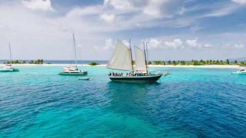 Sailboats In Tropical Caribbean Seascape Tropical seascape with sailboat and catamarans near sandy island