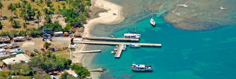 Tropical Marina With Boats And Beaches Aerial View Aerial view of tropical marina with boats, piers, and sandy beaches surrounded by palm trees