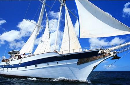 Luxury Sailing Yacht On Blue Ocean Waters Luxury multi-mast sailing yacht with white sails cruising on blue ocean