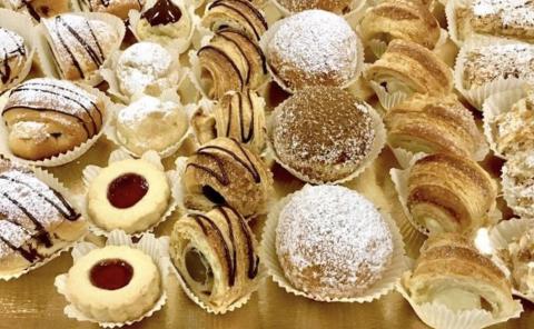 Assorted Pastries: Cookies, Eclairs & Croissants Assorted pastries including cookies, eclairs, and cream puffs in a bakery display.