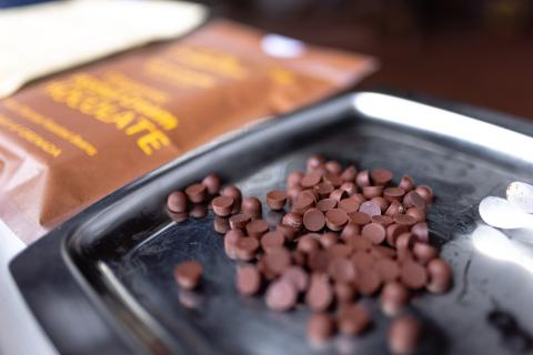 Milk Chocolate Chips For Baking On Tray Milk chocolate chips on tray with blurred Belgian chocolate package