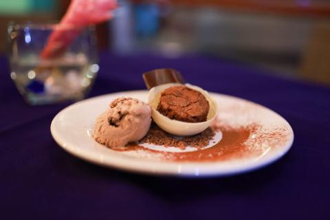 Gourmet Chocolate Dessert Plate In Cozy Restaurant Chocolate-themed dessert plate with ice cream and mousse in a cozy restaurant setting.