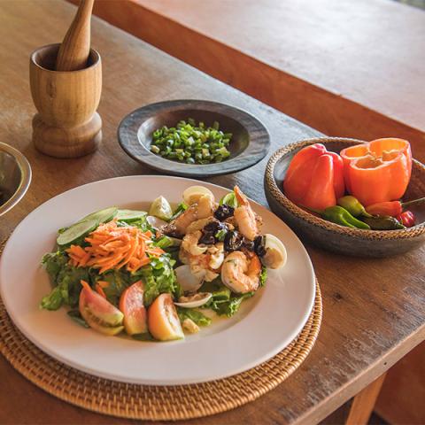Healthy Seafood Salad With Fresh Greens And Fruits Colorful seafood salad with shrimp, apples, and greens on wooden table