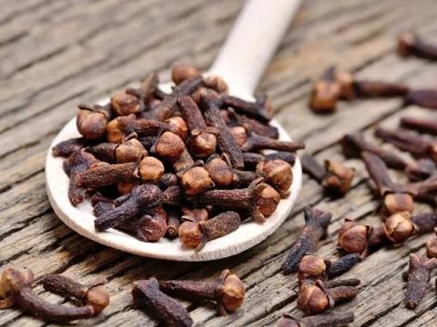 Spoonful Of Cloves On Wooden Background Cloves on wooden spoon - essential spice for global cuisines and beverages
