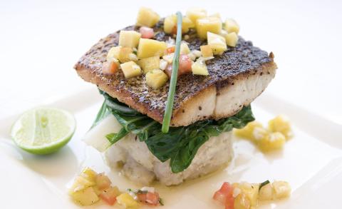 Seared Mahi Mahi With Mango Salsa And Spinach Seared fish fillet with mango salsa, spinach, and mashed potatoes on a plate.