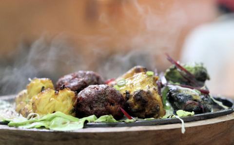 Grilled Chicken Sizzler Plate With Fresh Garnish Sizzling grilled chicken and meats on hot plate with greens