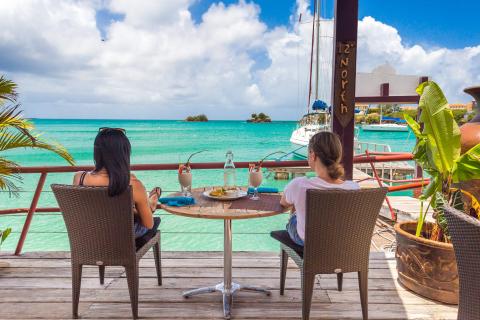 Tropical Waterfront Dining At 12° North Two people dining by sea under