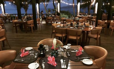 Outdoor Restaurant Dining By Water With Evening Lights Cozy outdoor restaurant dining area by the water with string lights and guests