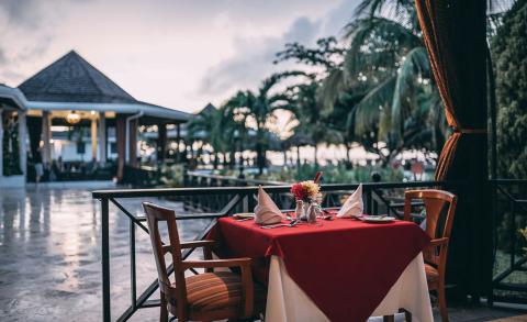 Romantic Tropical Resort Dinner Setting Romantic dinner setup for two on a balcony overlooking a tropical resort.