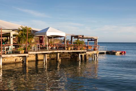 Scenic Outdoor Dining Pier Restaurant By Tranquil Waters Scenic pier restaurant with covered dining area and serene sea backdrop