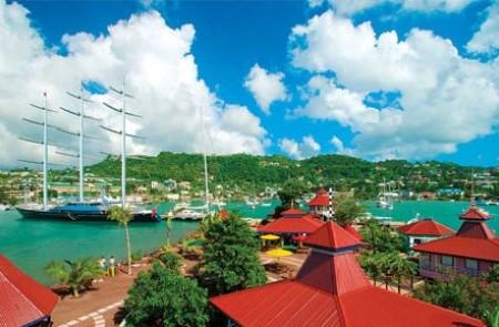 Tropical Harbor Yachting Scene With Schooner Tropical harbor scene with sailing boats and red-roofed buildings