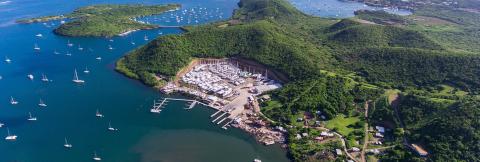 Aerial View Of Lush Coastal Marina With Boats Aerial view of a lush coastal marina with boats, ideal for water activities.