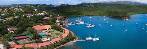 Luxury Tropical Seaside Resort With Marina And Pools Aerial view of a tropical seaside resort with marina, lush greenery, and tennis court.