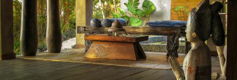Asian-Inspired Outdoor Relaxation Area With Statue Asian-inspired outdoor relaxation area with wooden decor and lush greenery