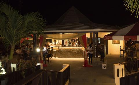 Chic Outdoor Bar And Dining Area Night Scene Outdoor dining area at night with central bar and cozy, warmly lit ambiance.