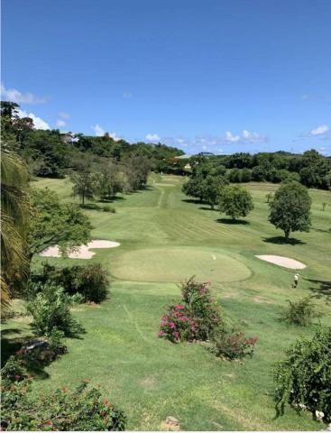 Scenic Golf Course With Lush Greens And Bunkers Scenic golf course with lush greens, sand bunkers, and distant hills on sunny day