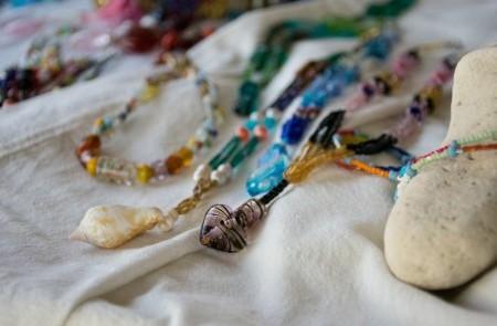 Colorful Bead Necklaces With Heart Pendant Display Colorful bead necklaces with a heart pendant on fabric, possibly for sale.