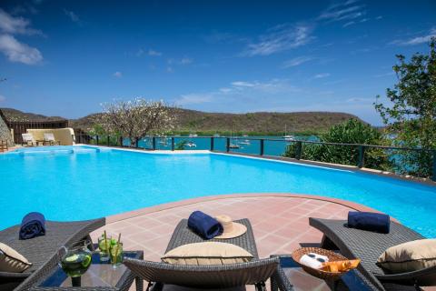Luxury Infinity Pool Overlooking Scenic Bay With Boats Luxurious infinity pool and patio overlooking scenic bay with boats