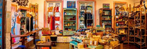 Eclectic Boutique Gift Shop - Artisanal Clothing & Decor Colorful boutique gift shop interior with eclectic local artisan items.