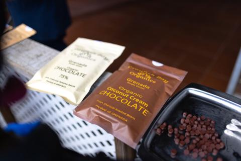 Organic Grenada Chocolate Packages At Tasting Event Assorted organic chocolates on display, including Grenada 75% and coconut cream flavors.