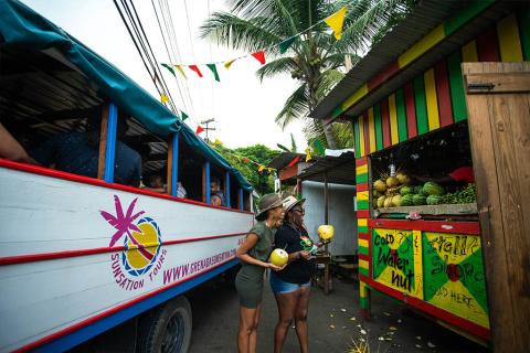 Tropical Fruit Stand With Tour Bus In Caribbean Tropical fruit stand with coconuts, vibrant colors, and tour bus in Caribbean.