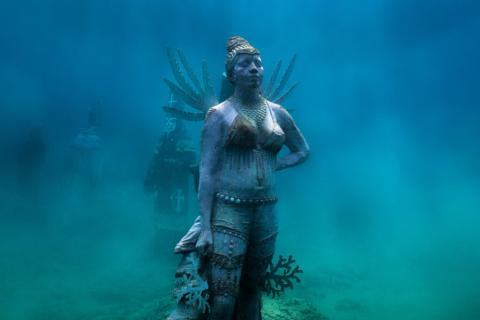 Underwater Sculpture Garden With Cultural Figures Underwater sculpture museum with cultural motifs and marine life.