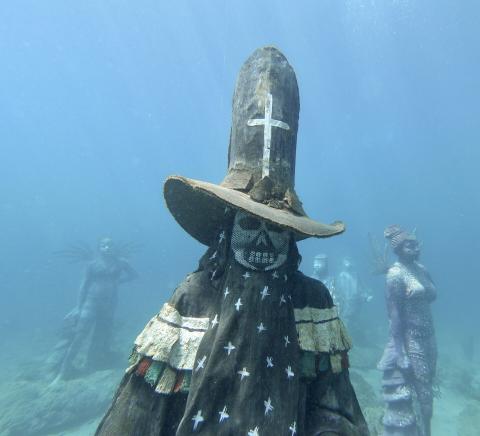 Underwater Religious Sculpture Exhibit With Angel Underwater religious sculptures with mesh-masked figure and angelic statue