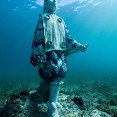 Underwater Jesus Statue With Marine Life Underwater statue of Jesus with ornate design, surrounded by marine life.