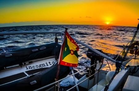 Sunset At Sea With Incognito Boat Flag Display Sunset ocean view with boat named Incognito, colorful flag displayed