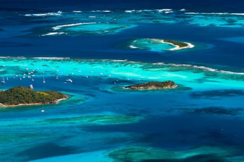 Tropical Archipelago Aerial View With Coral Reefs Aerial view of a tropical archipelago with clear waters, coral reefs, and boats