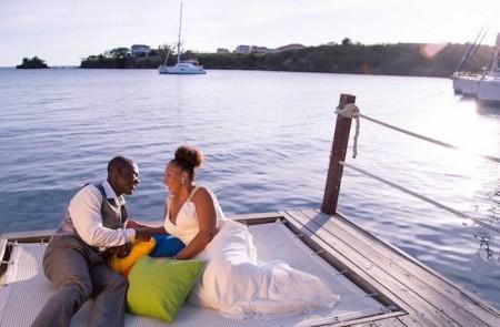 Romantic Couple On Dock At Sunset With Boats Couple in suit and white dress enjoying sunset on dock with boats