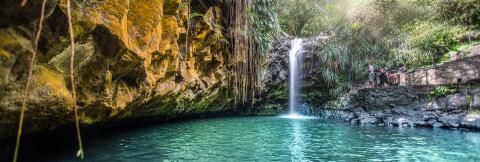 Scenic Waterfall And Lush Cliffs With Viewing Platform Scenic waterfall with turquoise pool and lush cliffs viewed from stone platform.