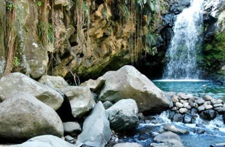 Scenic Waterfall And Rocky Pool In Lush Landscape Scenic waterfall with serene pool, surrounded by lush cliffs and foliage.