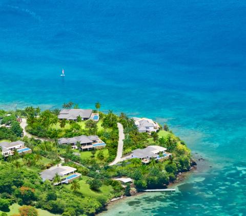 Luxurious tropical beach resort with bungalows and sailboat