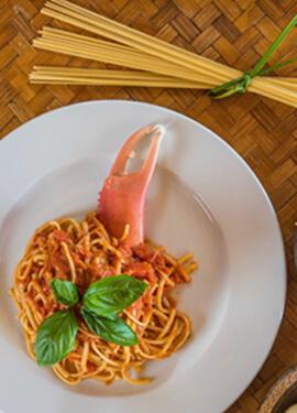 Delicious spaghetti with lobster and tomato sauce, garnished with basil on woven mat