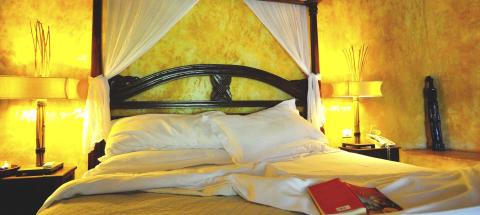 Cozy bedroom with wooden bed frame, floral headboard, and white canopy.