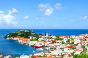 Scenic coastal town with lighthouse, colorful buildings, and calm ocean.