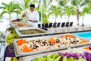 Colorful rice dish at poolside resort buffet with chef in background