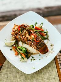 Elegant lobster tail with vegetables and lime, perfect for a fine dining experience.
