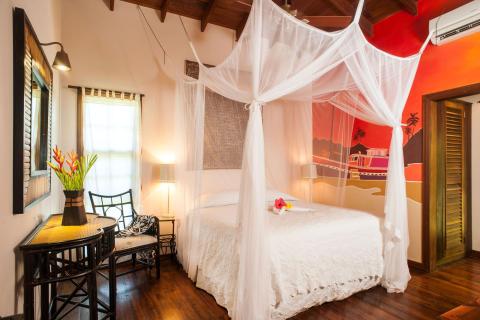 Cozy bedroom with tropical mural, wooden bed, and elegant white bedding
