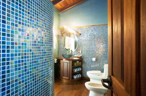 Stylish bathroom with blue tiles, wooden vanity, and rustic beams.