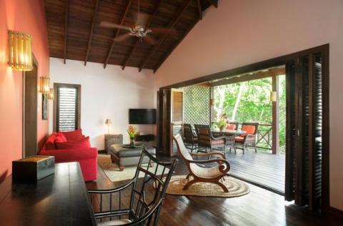 Stylish living room with red sofa and outdoor dining area