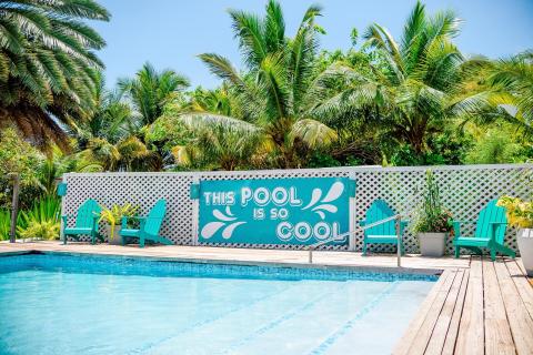 Colorful tropical pool area with aqua decor and palm trees