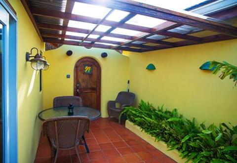 Cozy indoor patio with yellow walls, wicker furniture, and natural lighting.
