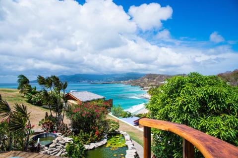 Scenic tropical beach view from resort with lush garden and ocean backdrop
