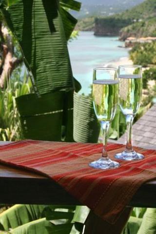 Champagne glasses on table with tropical bay view, luxury setting
