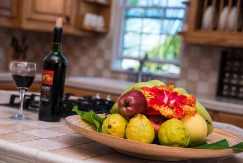 Cozy kitchen with fruit bowl, wine, and view of greenery