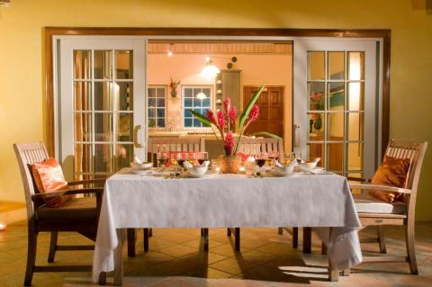 Elegant outdoor dinner setup with floral centerpiece on patio.