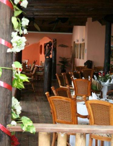 Cozy restaurant interior with rustic decor, wooden chairs, and festive elements.